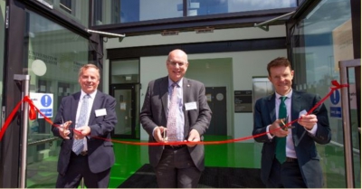 three men smile as they cut the red ribbon on. the birmingham energy innovation centre