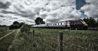 a cross country train travelling past green fields