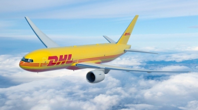 A DHL branded yellow aeroplane in the clouds