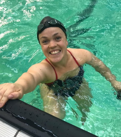 Ellie Simmonds smiles at the camera from the pool