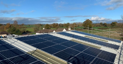 3 large solar panels on a roof with a countryside scene behind