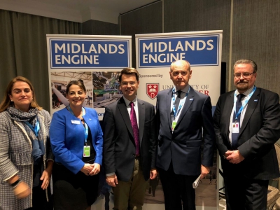 a group of people stand in front of two midlands engine roller banners