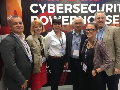 a group stands in front of a cyber security poster