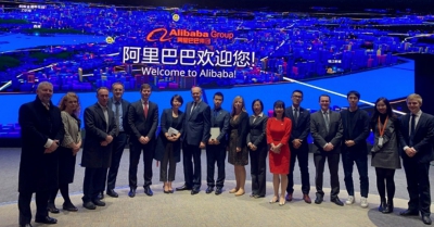 A large group of people from the Midlands Engine and Chinese leaders summit in front of a sign that read welcome to Alibaba
