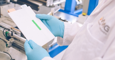 A blue gloved scientist holds a white paper folder