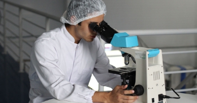 a technician looks into a microscope